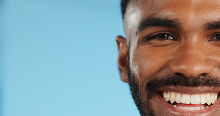 Image showing Half, face and black man with smile in studio, blue background and mockup space with happiness or advertising. Portrait, closeup and marketing for skincare, wellness or healthy dermatology care