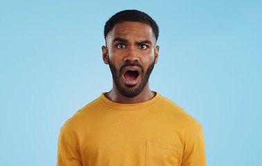 Image showing Face, surprise and man with gossip, news and announcement on a blue studio background. Portrait, person and model with shock, expression and mockup space with wow, omg and emoji with secret and icon