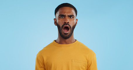 Image showing Face, surprise and man with gossip, news and announcement on a blue studio background. Portrait, person and model with shock, expression and mockup space with wow, omg and emoji with secret and icon