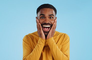 Image showing Hands on face, wow and excited black man in studio isolated on a blue background mockup space. Portrait, surprise and happy person in shock for good news, information and winner of bonus promotion