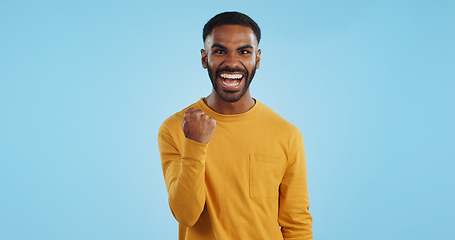 Image showing Wow, news and happy man in studio with winner, fist or celebration, dance or victory on blue background. Surprise, success or portrait of guy winner with energetic reaction to prize, giveaway or deal
