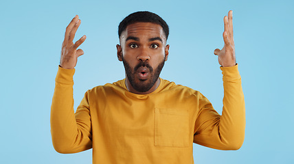 Image showing Wow, face and man with mind blowing news in studio with shocked, gesture or expression on blue background. Surprise, portrait and male model with hand emoji for unexpected deal, announcement or info