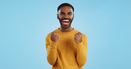 Image showing Wow, news and happy man in studio with winner, fist or celebration, dance or victory on blue background. Surprise, success or portrait of guy winner with energetic reaction to prize, giveaway or deal