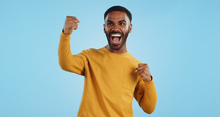 Image showing Wow, news and happy man in studio with winner, fist or celebration, dance or victory on blue background. Surprise, success or portrait of guy winner with energetic reaction to prize, giveaway or deal