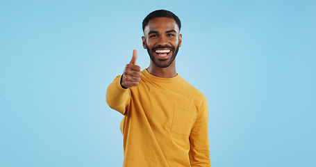 Image showing Face, smile and man with thumbs up in studio for support, motivation or vote on blue background. Happy, portrait and excited male model with hand emoji for winning, thank you or success gesture