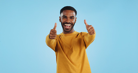 Image showing Happy, face and man with thumbs up in studio for support, motivation or vote on blue background. smile, portrait and excited male model with hand emoji for winning, thank you or success gesture