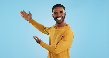 Image showing Happy, face and man with hand pointing in studio for news, presentation or platform offer on blue background. Smile, portrait and male model show promo, launch or space for coming soon announcement