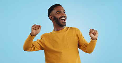 Image showing Dance, man and excited for party in studio to celebrate success, promotion and winning lotto on blue background. Happy young model, giveaway winner and energy for disco, groovy music and freedom