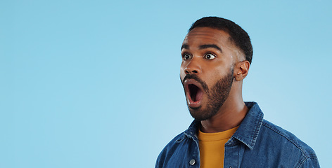 Image showing Black man, surprise announcement and shock on face, expression and drama on blue background. Wow, reaction to news and alarm in studio with gossip, alert and mockup space with mind blown in studio