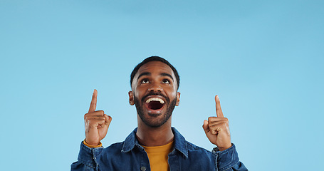 Image showing Happy man, pointing and news announcement with portrait in studio, surprise emoji and advertising. Mockup, mexican person and smiling in casual fashion for offer and notification by blue background