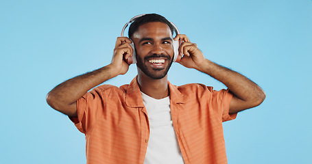 Image showing Man, student and headphones for listening to music, dance and mental health for education and wellness in studio. Young african person for audio streaming service, techno or rave on a blue background