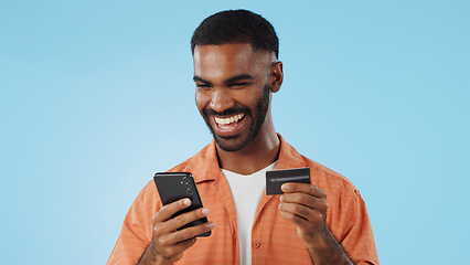 Image showing Man, credit card and excited with phone, studio and thinking of sale, promo code or info by blue background. Online shopping, easy payment and happy for financial freedom, fintech app or smartphone