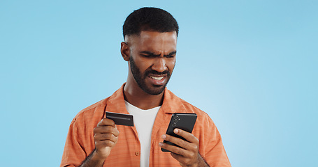 Image showing Man, credit card and confused with phone, studio and thinking of price, code or info by blue background. Online shopping, payment glitch or mistake with declined account with fintech with smartphone