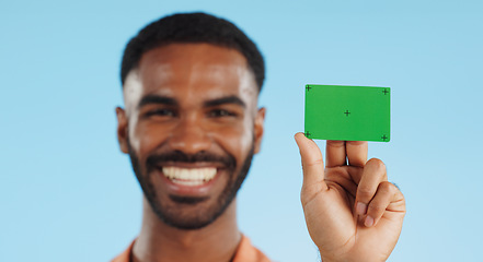 Image showing Man, credit card and happy with green screen in studio for mockup, bank logo and face by blue background. Person, space and chromakey with tracking markers for fintech brand, review or promotion