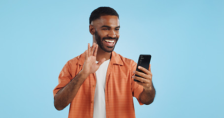 Image showing Video call, wave and man with a smartphone, showing and conversation on a blue studio background. Person, speaking and model with a cellphone, online chat and communication with network or connection