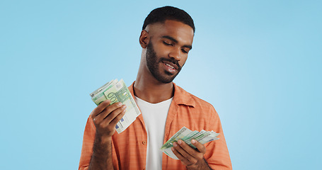 Image showing Man, count cash and happy in studio with success, bonus or promotion with winning by blue background. Investor, trader or person with Euro money, salary or savings with smile for financial freedom go