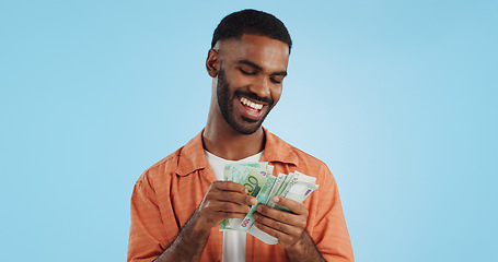 Image showing Man, count cash and happy in studio with success, bonus or promotion with winning by blue background. Investor, trader or person with Euro money, salary or savings with smile for financial freedom go