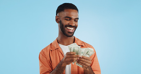 Image showing Man, count money and happy in studio with success, bonus or dollar promotion with winning by blue background. Investor, trader or person with cash, salary or savings with smile for financial freedom