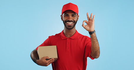 Image showing Delivery man, box and okay hands for success, product excellence and courier services in studio. Happy face of supply chain worker or african person for package or distribution on blue background