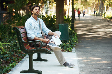 Image showing Man, tourist and map on bench in park outdoor for travel, direction or location for explore in nature. Person, photography or paper on lap for adventure, journey or photographer with exploration