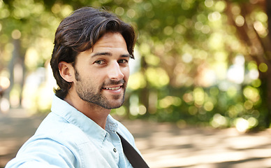 Image showing Relax, portrait or happy man in nature on a bench in summer for holiday vacation or break in garden. Freedom, smile or face of person in park resting or waiting in a natural environment for wellness