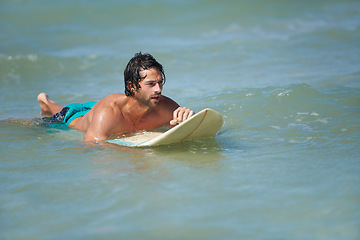 Image showing Man, surfing and sea with workout, training and waves with water sport and exercise outdoor of athlete. Surfer, freedom and vacation by the ocean and beach for summer wellness and fitness in nature