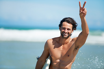 Image showing Surfing, portrait and happy man with peace hands at a beach for travel, freedom or adventure. Face, smile and male surfer with v sign at sea for water sports, training or summer vacation in Miami