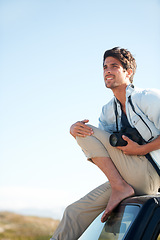 Image showing Man, photographer and camera on car or smile for road trip, adventure or journey or thinking with travel. Person, photography or memories for vacation, holiday scenery on drive or blue sky in nature