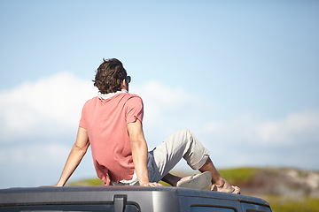 Image showing Back, man and travel on car roof for scenery, nature and fresh air on adventure or vacation in South Africa. Person, tourist or traveler on rooftop of van with sunglasses for view or journey or rear