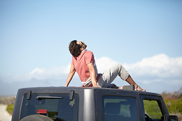 Image showing Travel, man and sitting on van roof for scenery, nature and fresh air on adventure or vacation in South Africa. Person, tourist or traveler on rooftop of car with sunglasses for view or road trip