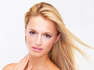 Image showing Portrait, hair and wind with a natural woman in studio on a white background for luxury or keratin treatment. Face, beauty and haircare with a confident young model touching her skin at the salon