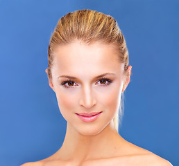 Image showing Portrait, spa and beauty with a woman closeup in studio on a blue background for natural wellness or cosmetics. Face, skincare and makeup with a confident young model at the salon for dermatology