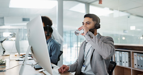 Image showing Happy businessman, call center and drinking water in customer service or telemarketing at office. Thirsty man, consultant or agent talking with headphones and drink for online advice, support or help