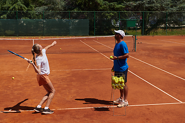 Image showing A professional tennis player and her coach training on a sunny day at the tennis court. Training and preparation of a professional tennis player