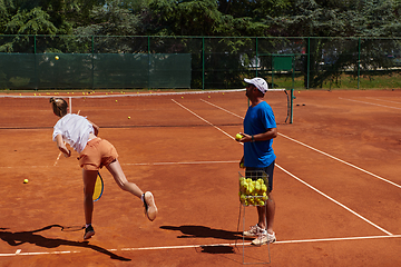 Image showing A professional tennis player and her coach training on a sunny day at the tennis court. Training and preparation of a professional tennis player