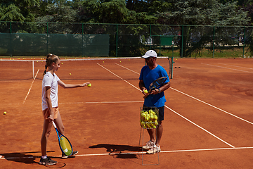 Image showing A professional tennis player and her coach training on a sunny day at the tennis court. Training and preparation of a professional tennis player