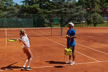 Image showing A professional tennis player and her coach training on a sunny day at the tennis court. Training and preparation of a professional tennis player