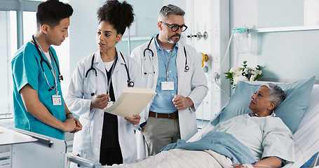 Image showing Healthcare, documents and a medical team of doctors checking on a patient in recovery or rehabilitation. Medicine, teamwork and explain with a group of health professionals in a hospital for wellness