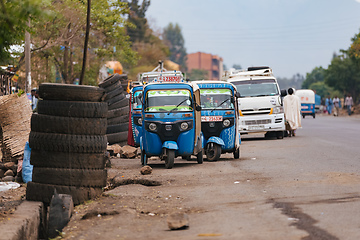 Image showing Street in Addis Zemen showcasing traditional blue tuk-tuk vehicles, a popular mode of transportation in the cities in Ethiopia.