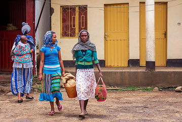 Image showing An authentic snapshot of urban life in Bahir Dar, showcasing a woman walking down the vibrant streets with a shopping bag.