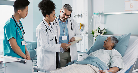 Image showing Healthcare, documents and a medical team of doctors checking on a patient in recovery or rehabilitation. Medicine, teamwork and explain with a group of health professionals in a hospital for wellness