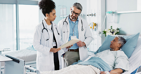 Image showing Healthcare, documents and a medical team of doctors checking on a patient in recovery or rehabilitation. Medicine, teamwork and explain with a group of health professionals in a hospital for wellness