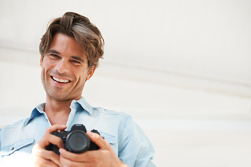 Image showing Smile, camera and young man photographer at a photoshoot for creative work project. Happy, photography and portrait of handsome male person with dslr device for art career by white studio background.