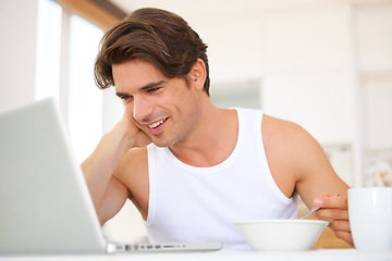 Image showing Laptop, eating and man watching a movie, film or show on streaming website or the internet. Technology, smile and young male person enjoying cereal and video on social media with computer at home.