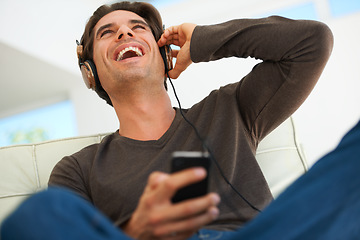 Image showing Man, happiness and headphones with cellphone, music and entertainment, subscription and relax at home. Technology, audio streaming and listening to radio, low angle and fun with sound and smile