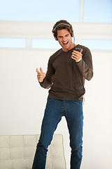 Image showing Dance, headphones or happy man singing with phone to celebrate freedom, karaoke subscription or hearing digital audio. Excited guy listening to music, radio or sound on smartphone with energy at home