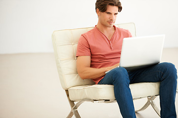 Image showing Man, remote work and typing with laptop on couch for social media, digital network and online shopping. Serious freelancer on computer for reading email, website article and research in modern house