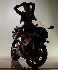 Image showing Sexy, leather jacket and woman in bikini on motorbike in studio isolated on a white background. Body, serious model and swimsuit on motorcycle for fashion, freedom to travel or thinking of beauty