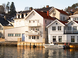 Image showing Facade, water and home by lake in Norway, Europe and boat for tourism, travel or vacation. Exterior, house and Scandinavian building by river, vintage architecture or traditional property real estate