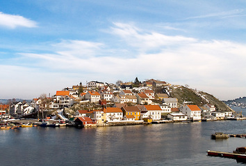 Image showing Island, water and houses at ocean in Norway, Europe and tourism, travel or vacation. Exterior, home and Scandinavian buildings at sea, vintage architecture or traditional property with boats at port